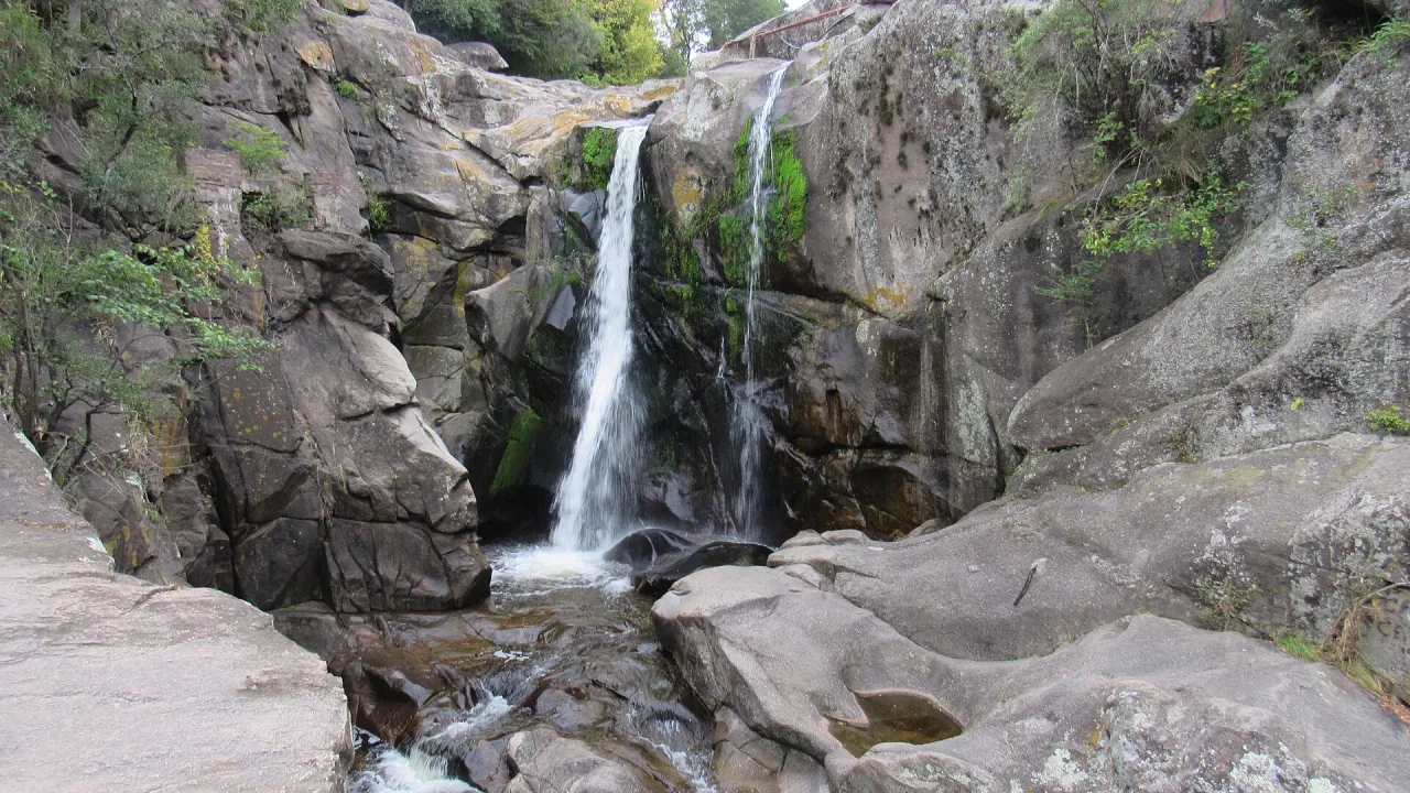 Cascada que cae entre grandes rocas de granito en Tanti