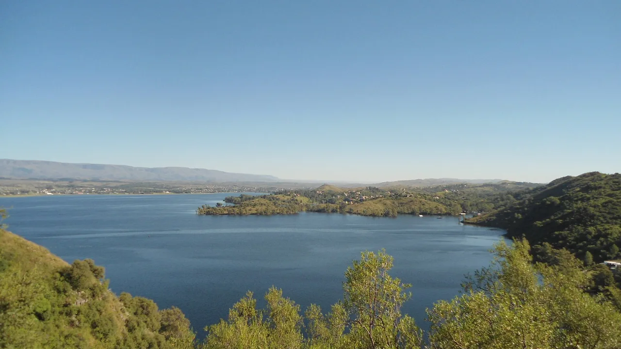 El lago Los Molinos rodeado de sierras bajas en un día despejado