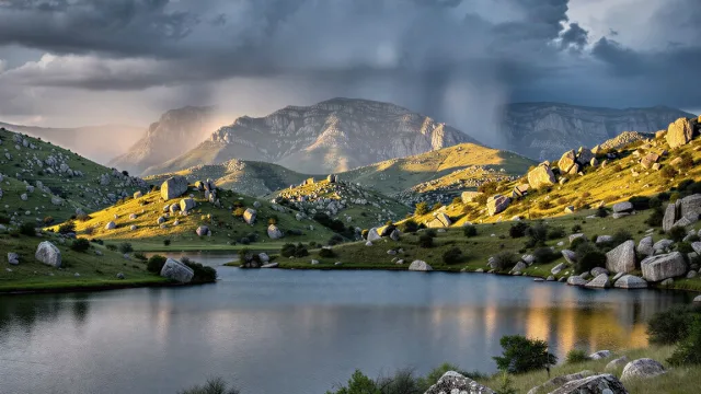 Ilustración fotorrealista de nubes de tormenta y cortinas de lluvia sobre sierras rocosas, con un lago y lomas verdes iluminadas por el sol